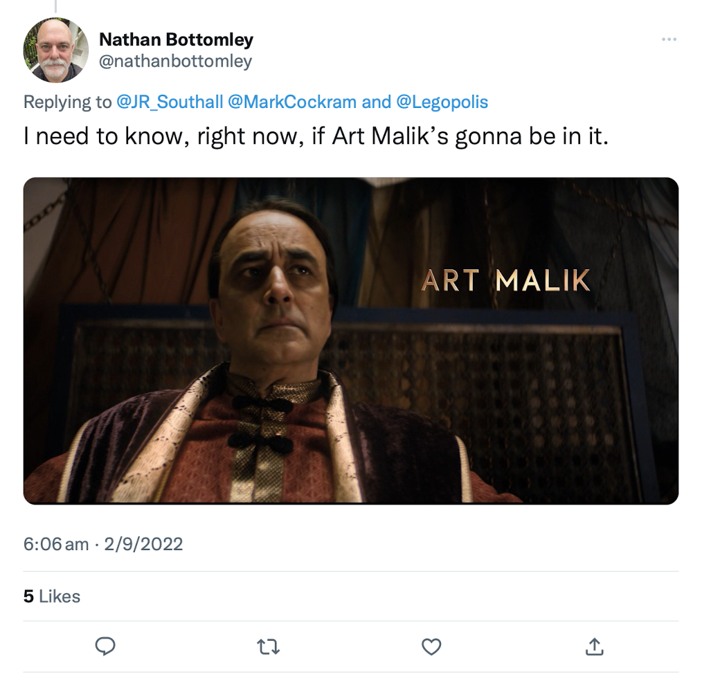 Screenshot of a tweet by Nathan Bottomley, saying "I need to know, right now, if Art Malik’s gonna be in it." The featured image is a screenshot from  the Next Time trailer of The Woman Who Fell to Earth, showing an austere Art Malik from the episode The Ghost Monument, with his name next to him  in gold lettering.